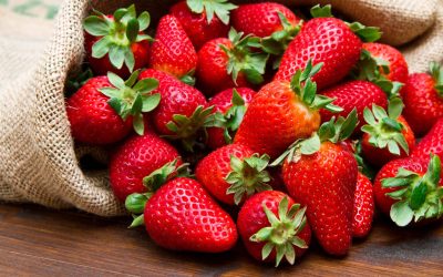 fresh strawberry in burlap sack on wood